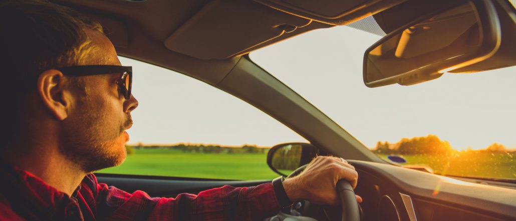 Closeup of male business owner driving his personal car for business purposes 