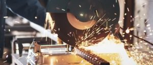 Des étincelles jaillissent lorsqu’un mécanicien utilise une scie électrique pour couper du métal
