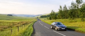 black car driving on road